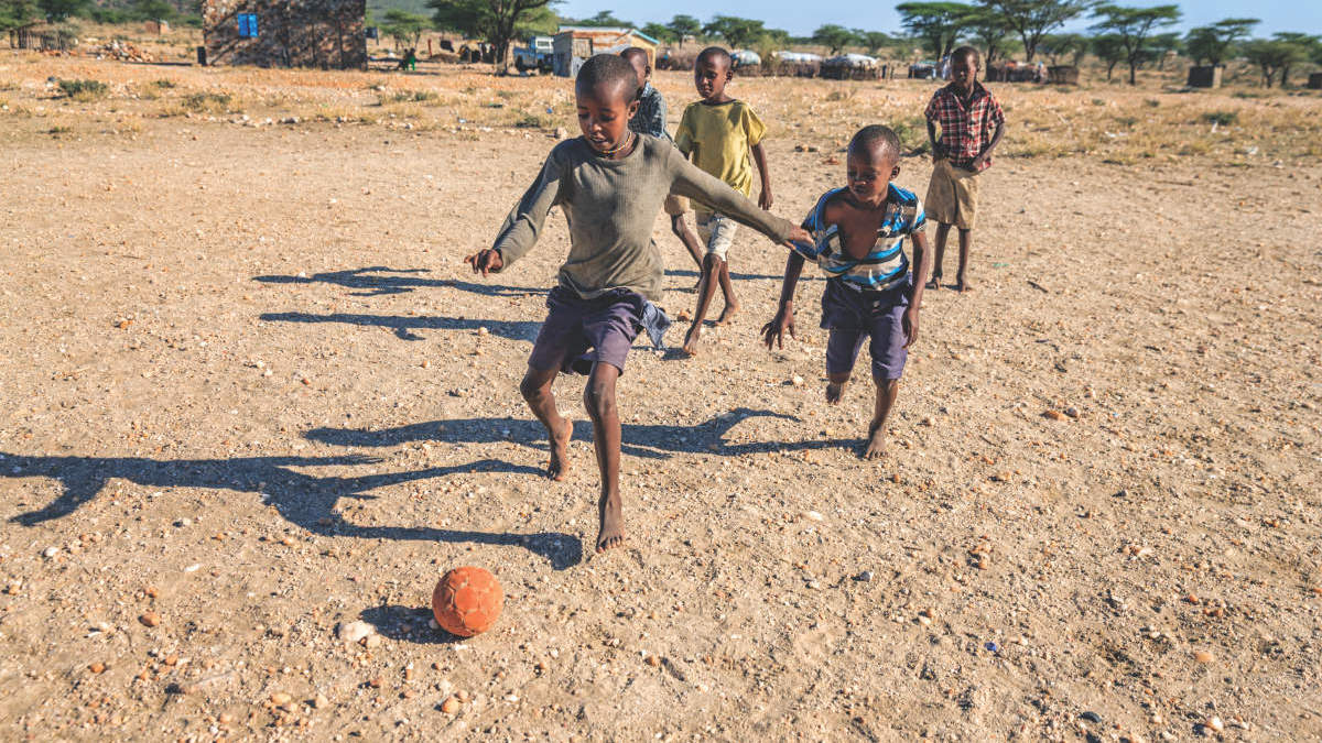 QFT, five boys playing soccer.